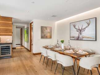 Experience elegant dining in this beautifully appointed space, featuring a stunning deer artwork and a meticulously set table for six.