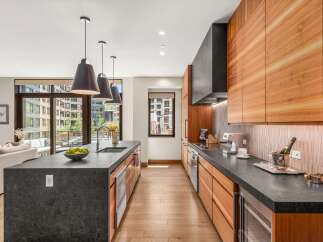Experience modern luxury in this stunning kitchen featuring a large waterfall island with a built-in sink and ample seating.