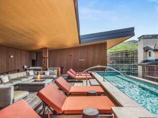 Experience luxury outdoor living with this stunning rooftop oasis, featuring a sleek plunge pool and comfortable lounge seating.