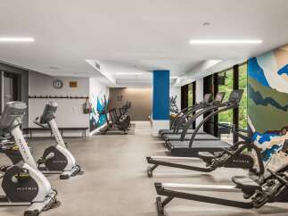 Elevate your fitness routine in this modern gym, featuring state-of-the-art Matrix cardio equipment including treadmills and stationary bikes.