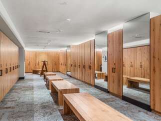 Experience luxury and convenience in this beautifully designed locker room, featuring warm wood lockers and ample seating.