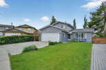 Charming grey siding home with a spacious front lawn and a detached garage.