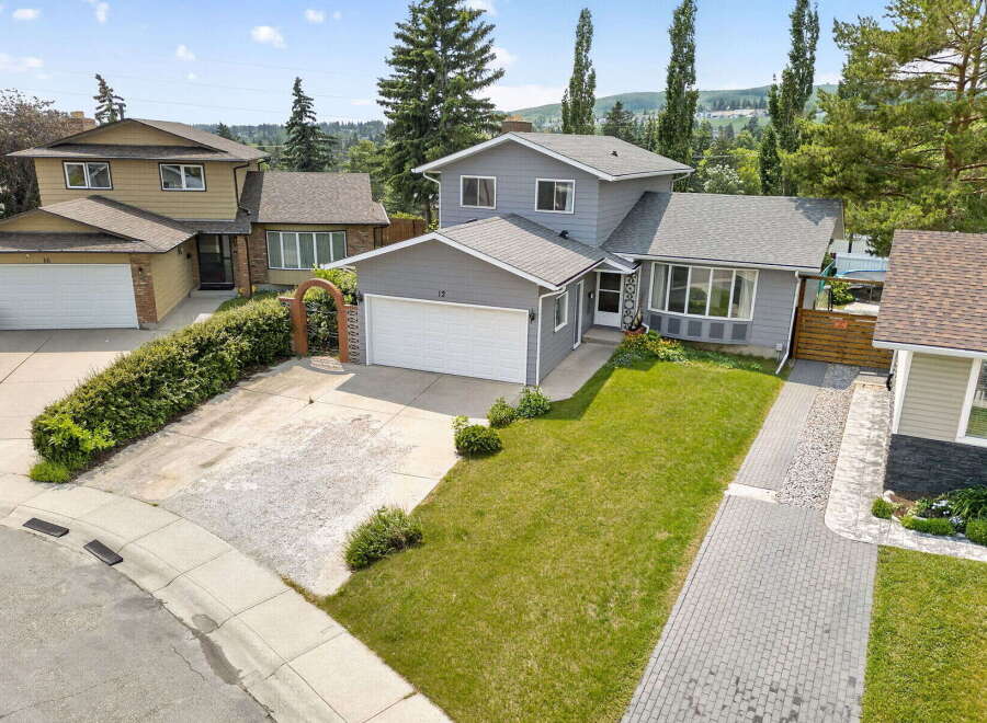 Discover this charming home featuring a well-maintained lawn and a paved driveway leading to an attached garage.
