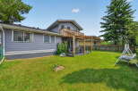 Enjoy outdoor living in this spacious backyard featuring a wooden deck with a pergola, perfect for entertaining or relaxing.