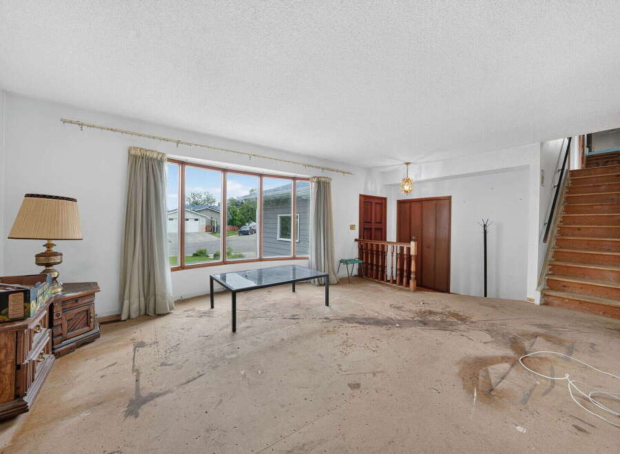 This spacious living room features a large bay window offering abundant natural light and views of the neighborhood.