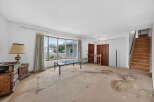 This spacious living room features a large bay window offering abundant natural light and views of the neighborhood.