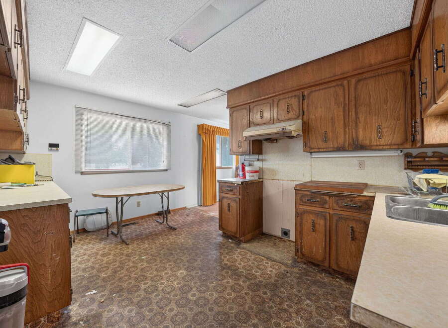 This spacious kitchen features ample natural light from the large window, complemented by overhead fluorescent lighting.
