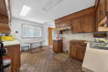 This spacious kitchen features ample natural light from the large window, complemented by overhead fluorescent lighting.