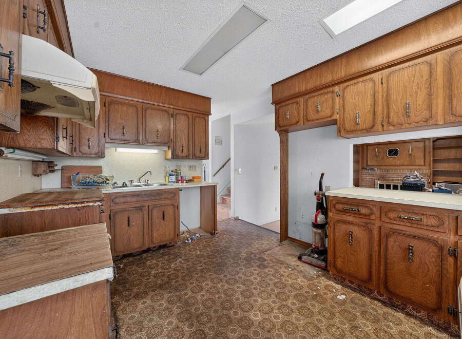 This kitchen features classic wood cabinetry and a retro-style patterned floor, offering a unique vintage aesthetic.