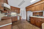 This kitchen features classic wood cabinetry and a retro-style patterned floor, offering a unique vintage aesthetic.