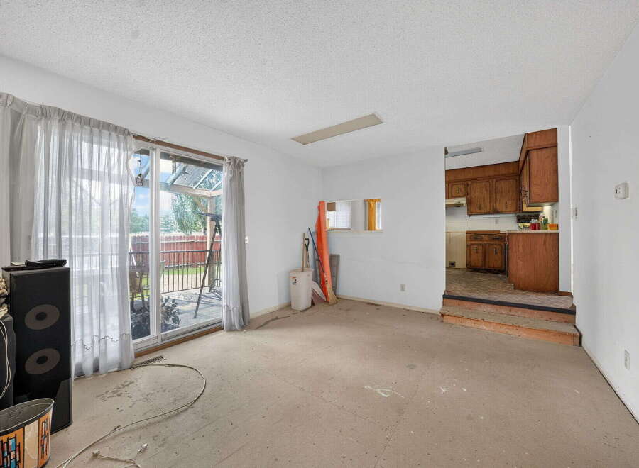 This spacious living area offers a bright and airy atmosphere with large sliding glass doors leading to an outdoor patio.