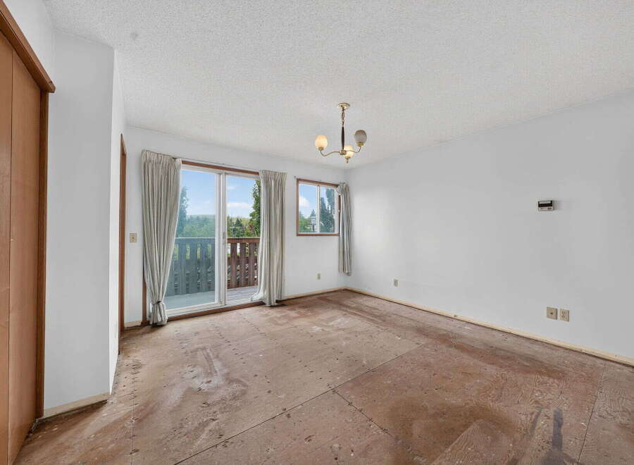 This spacious room features a sliding glass door leading to a balcony with scenic views, perfect for enjoying the outdoors.
