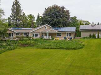 Discover this charming home featuring a spacious lawn and lush landscaping, perfect for outdoor enjoyment.