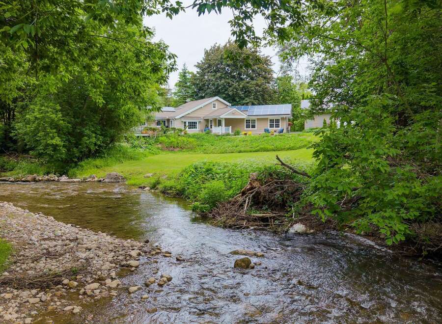 Experience serene living with this charming home nestled beside a babbling brook.