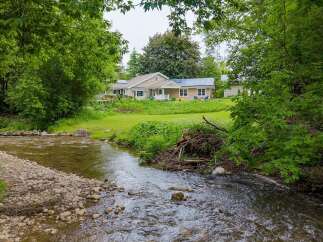 Experience serene living with this charming home nestled beside a babbling brook.