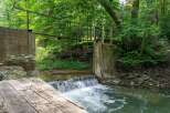 Discover a serene natural escape with this charming property featuring a picturesque waterfall and a rustic wooden bridge.
