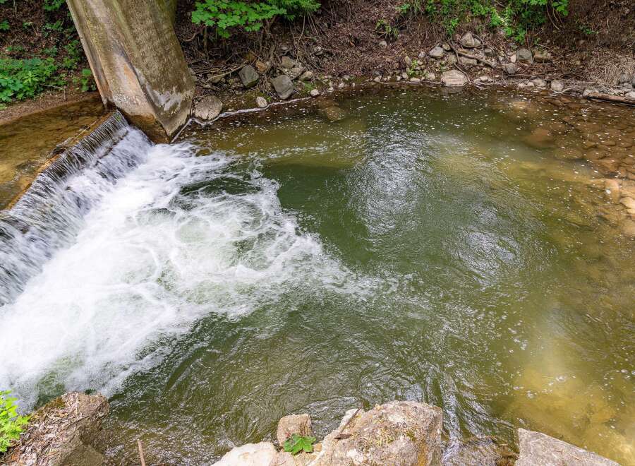 Discover a serene natural setting with this property, featuring a charming waterfall cascading into a clear, inviting pool.