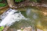 Discover a serene natural setting with this property, featuring a charming waterfall cascading into a clear, inviting pool.