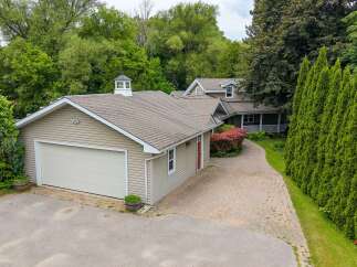 Discover this charming property featuring a spacious garage and a welcoming home nestled amidst lush greenery.