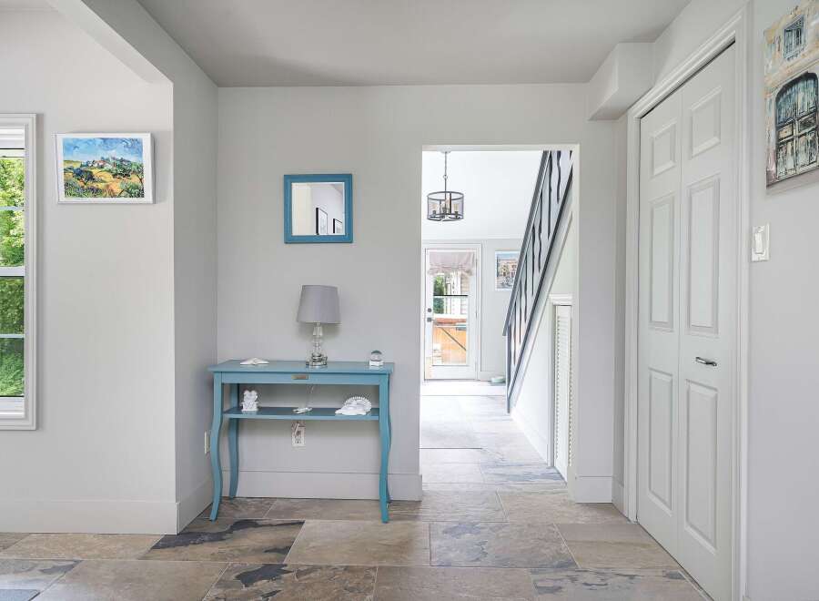 Step into this charming entryway featuring a bright blue console table adorned with decorative accents and a crystal lamp.