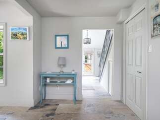 Step into this charming entryway featuring a bright blue console table adorned with decorative accents and a crystal lamp.