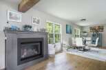 Experience the charm of this inviting living space, featuring a striking gray fireplace as the focal point.