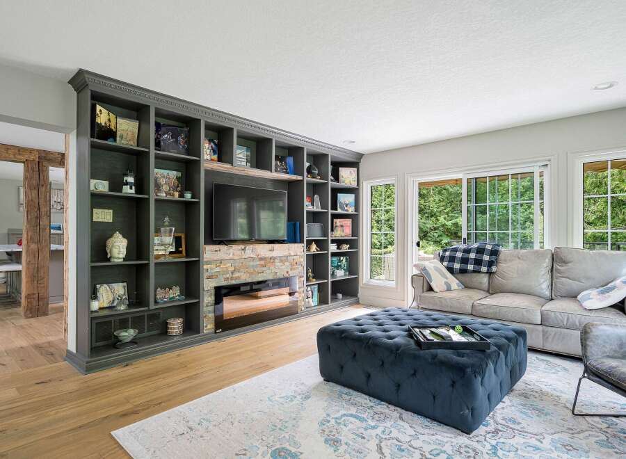 This living room boasts a stunning floor-to-ceiling built-in bookshelf with a modern fireplace and entertainment center.