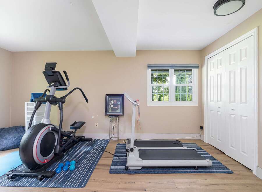 This home gym features a spacious elliptical machine and a compact treadmill, perfect for your cardio workouts.