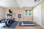This home gym features a spacious elliptical machine and a compact treadmill, perfect for your cardio workouts.