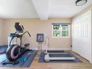 This home gym features a spacious elliptical machine and a compact treadmill, perfect for your cardio workouts.