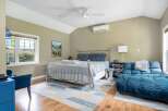 Experience comfort and style in this inviting bedroom, featuring a sleek metal-frame bed adorned with blue striped bedding and plush pillows.