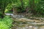 Discover a serene natural retreat with this charming property, featuring a picturesque stream flowing through lush greenery.