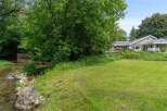 Enjoy serene living with this charming home featuring a beautiful creek and lush greenery.