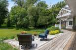 Enjoy outdoor living with this charming patio featuring comfortable seating and vibrant floral arrangements.
