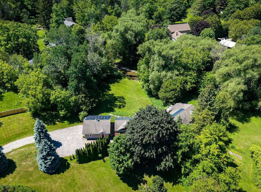 Discover this stunning property nestled amidst lush greenery, featuring a modern home equipped with solar panels for sustainable living.