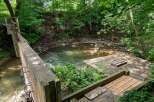 Discover a unique property featuring a charming creek running alongside a concrete structure, perfect for outdoor enthusiasts.