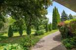 Discover a beautifully landscaped property featuring a charming gravel pathway winding through lush greenery.
