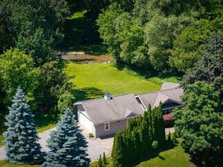 Nestled amidst lush greenery and mature trees, this property offers a serene retreat with a charming home and a tranquil stream.