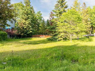 Discover a spacious, sun-drenched yard perfect for outdoor enjoyment and potential expansion.
