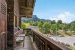 Enjoy breathtaking mountain views from this charming wooden balcony, complete with a rustic bench perfect for relaxing.