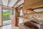 Step into this charming kitchen featuring rustic wooden cabinetry and warm-toned tiled backsplash.