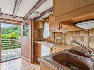 Step into this charming kitchen featuring rustic wooden cabinetry and warm-toned tiled backsplash.