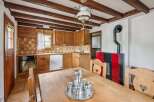 Experience rustic charm in this cozy kitchen featuring warm wooden cabinetry and a traditional tiled backsplash.
