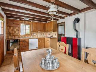 Experience rustic charm in this cozy kitchen featuring warm wooden cabinetry and a traditional tiled backsplash.