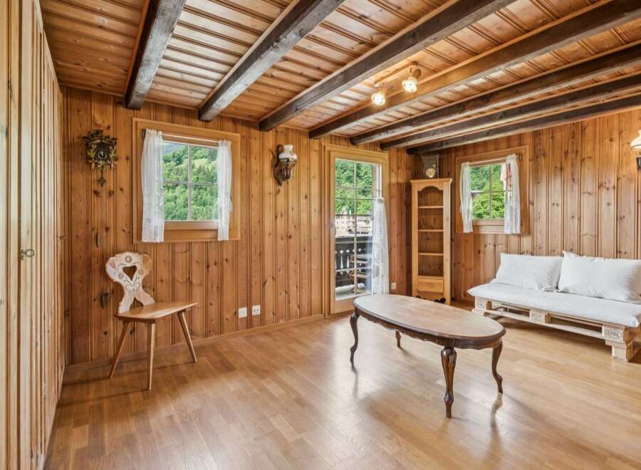 Experience rustic charm in this cozy wooden room, featuring exposed beams and a traditional cuckoo clock.