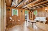 Experience rustic charm in this cozy wooden room, featuring exposed beams and a traditional cuckoo clock.
