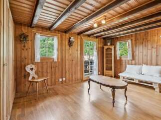 Experience rustic charm in this cozy wooden room, featuring exposed beams and a traditional cuckoo clock.