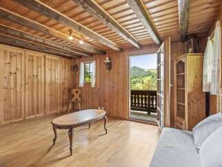 Experience rustic charm in this cozy wooden cabin living room, featuring exposed beams and a warm, inviting atmosphere.