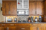 Experience rustic charm in this kitchen, featuring warm, distressed wood cabinetry that adds character and depth.
