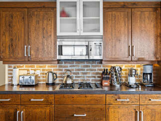 Experience rustic charm in this kitchen, featuring warm, distressed wood cabinetry that adds character and depth.